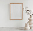 © irenastar - Frame mockup on white wall, modern vasen and home accessories composition. Design home decor. Template.