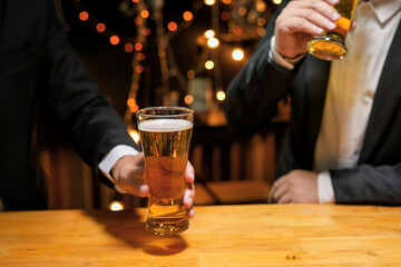 Wall Mural - food and drink male friends are happy drinking beer and clinking glasses at a bar or pub.