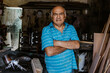© Marcos - portrait of latin senior man carpenter working in the wood at the furniture workshop in Mexico Latin America