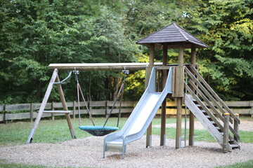 Slide on the playground, swings, wooden playground on sunset green background park wooden stairs ladder summer mood children playground kids playground natural equipment