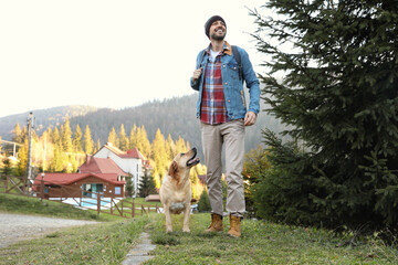 Canvas Print - Happy man and adorable dog in mountains. Traveling with pet