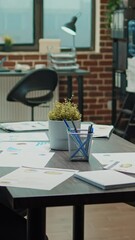 Canvas Print - Vertical video: Empty global company meeting table in business coworking space, workstation with documents and computer on desk. Corporate workplace filled with executive papers, startup development.