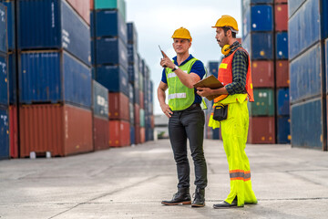 Wall Mural - Professional engineer container cargo foreman in helmets working standing and using walkie talkie checking stock into container for loading.logistic transport and business industry export