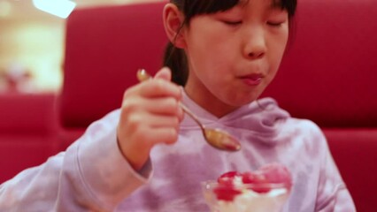 Poster - 外食先の店で楽しくいちごパフェを食べる小学生の女の子の様子