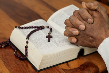 praying to God with hand on the bible on lack background stock photo