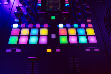 Wall Mural - Close up of DJ mixing console in party light