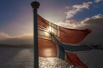 flag of the norwegian postal services, flown from the stern of a ferry/post-boat in finnfjorden, tro