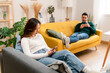 © The Attico Studio - Happy couple using smartphone on sofa