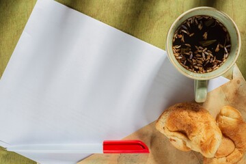 Wall Mural - Morning still life- a cup of tea and sweet cookies on a vintage green background. View from above table