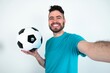 © Jihan - Photo of Young man holding a ball over white background do selfie