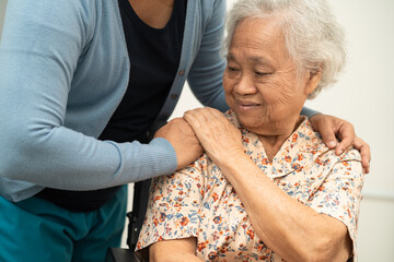 Caregiver help Asian elderly woman patient with love, care, encourage and empathy at nursing hospital, healthy strong medical concept.