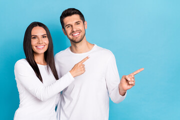 Wall Mural - Photo of two cheerful positive people indicate fingers empty space offer isolated on blue color background