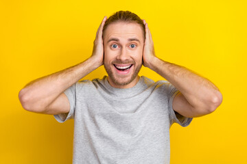 Sticker - Photo of cheerful glad man wear grey trendy clothes arms cover ears listen loud music disco holiday isolated on yellow color background