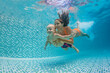 © Tropical studio - Happy family - mother, father with baby boy swimming, diving underwater with fun in blue pool. Healthy lifestyle, active parents, people water sports activity on summer vacation with child
