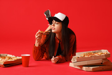 Poster - Young woman with boxes of tasty pizza lying on red background