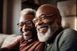 © Trinette Reed - Portrait of mature Black brothers sitting on sofa together laughing.  Generative AI