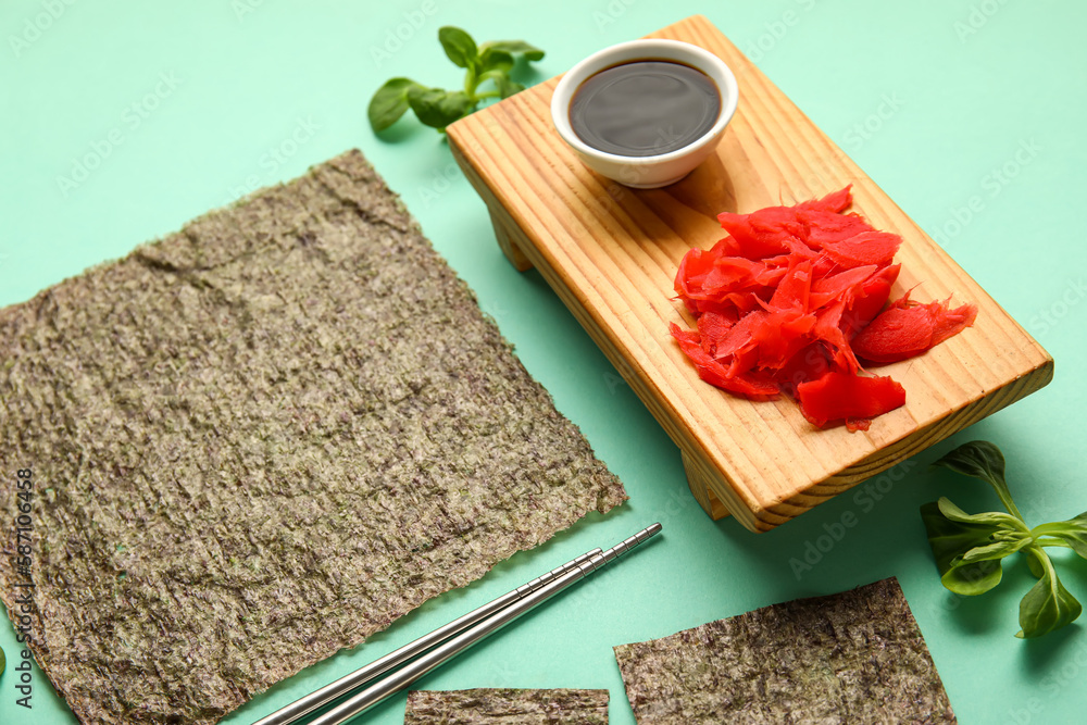 Composition with nori sheets, ginger and soy sauce on color background, closeup