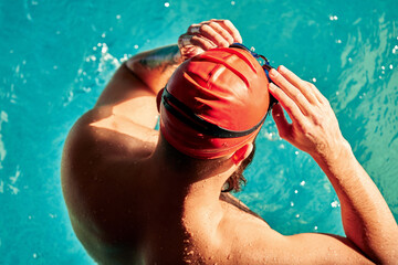 swimmer standing on diving board ready to jump into competition swimming pool