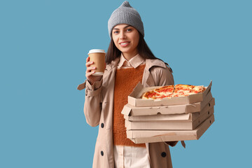 Poster - Young woman in hat with coffee cup and boxes of tasty pizza on blue background