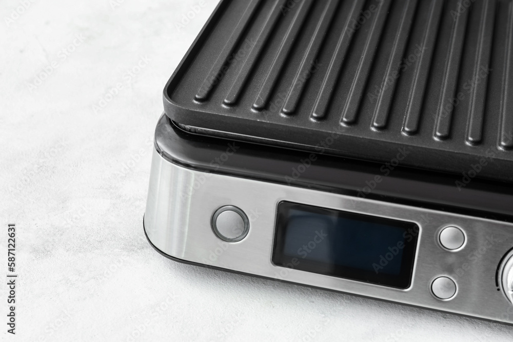 Control panel of modern electric grill on white table, closeup