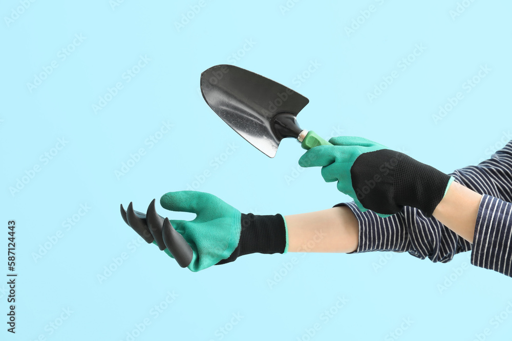 Female gardener with shovel on blue background