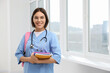 © New Africa - Smart medical student with notebooks in college hallway, space for text