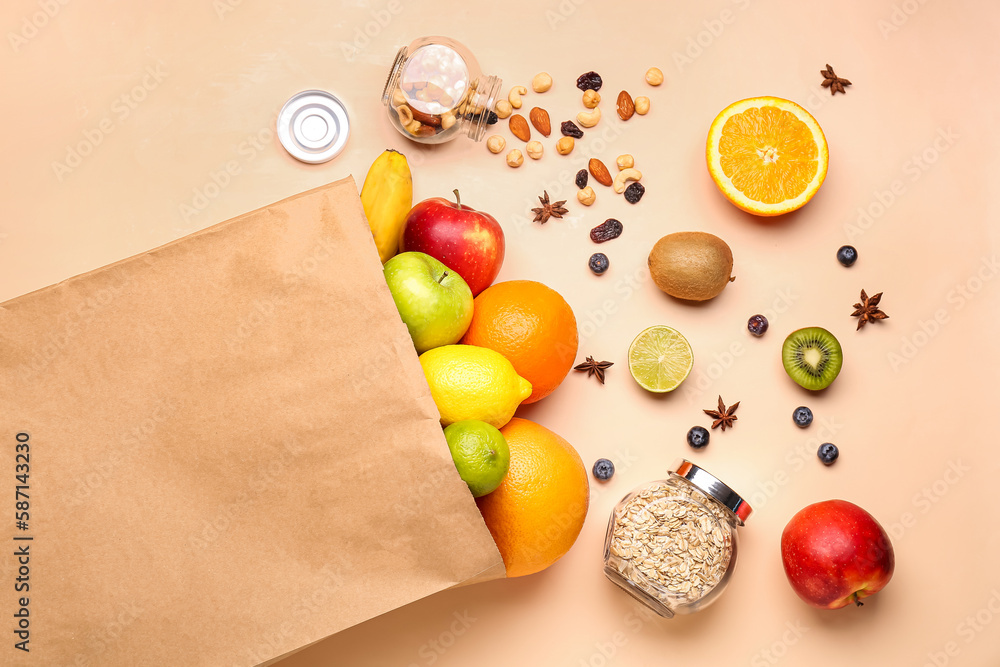 Paper bag with scattered fruits on beige background