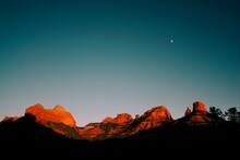 The Mountains And Bluffs Near Sedona At Sunset With The Moon Above