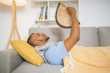 Man with fever, blowing air with a fan