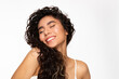 Happy beautiful young woman with black curly hair on white background