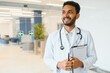 © Serhii - Portrait of happy friendly male Indian latin doctor medical worker wearing white coat with stethoscope around neck standing in modern private clinic looking at camera. Medical healthcare concept