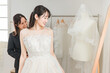 © buritora - 結婚式の準備でウェディングドレスの衣装合わせをするアジア人女性（試着・フィッティング）