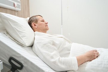 Wall Mural - Adorable sad man patient in the white medical ward