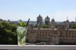 a cocktail in a glass sitting on a balcony railing overlooking london and the tower bridge