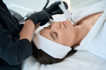 Professional cosmetologist doing skin rejuvenation, working in salon