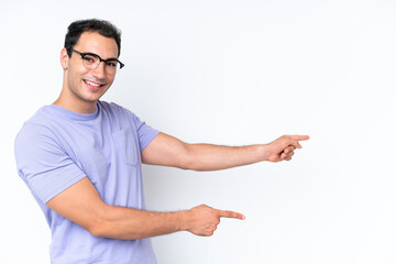 Wall Mural - Young caucasian man isolated on white background pointing finger to the side and presenting a product