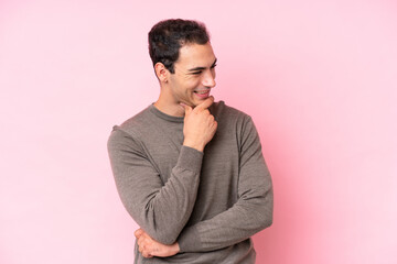 Sticker - Young caucasian man isolated on pink background looking to the side and smiling