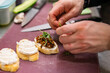 © pavel siamionov - man chef hand cooking tapas with tapenade and cream cheese on restaurant kitchen