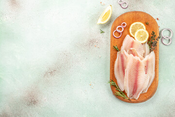 Wall Mural - Fresh fish tilapia fillet on a cutting board. Detox and healthy superfoods concept. place for text, top view