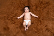 © gajendra - Cute smiling little indian baby wearing diaper lying on brown fur background. Asian two months old newborn baby.
