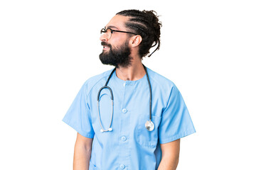 Wall Mural - Young doctor man over isolated chroma key background looking side