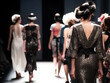 Fashion Show Models walk down a runway wearing a dress
