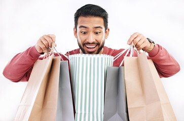 Canvas Print - Wow, sale and happy man with shopping bag in studio, excited for discount or purchase on white background. Deal, excited and indian guy with product form shop, mall or market while posing isolated