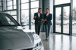 © standret - Two businessmen are working together in the car showroom