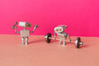 Robot weightlifter and robotics athlete train with heavy barbell and light fitness dumbbells. Power sport, fitness weightlifting workout