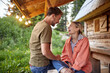 © luckybusiness - Couple  looking at each other and relaxing on  wooden cottage