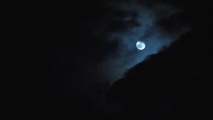 Wall Mural - a beautiful full moon in the night sky. dark black clouds moving nearby. mysterious and frightening 
