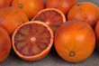 Orange sanguine coupée en deux sur fond d'oranges sanguines entières en gros plan
