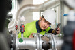 © เลิศลักษณ์ ทิพชัย - Asian male industrial engineer working Inspection and maintenance of factory water storage pipes or water systems in engineering plants.