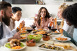 © MandriaPix - Lunch with friends, smiling young woman among people eating spaghetti with tomato sauce, typical Italian culinary speciality